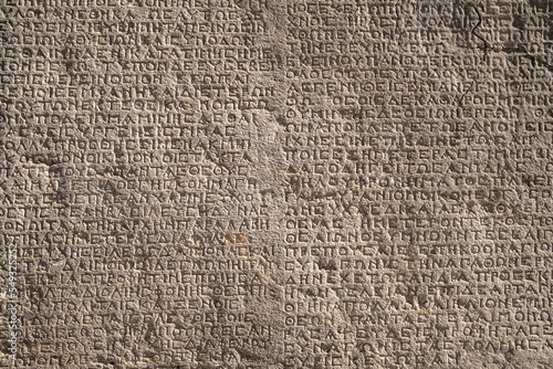 Obraz na płótnie Ancient greek inscriptions on the wall of archeological ruins close-up w salonie