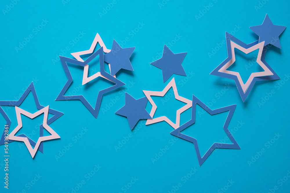 paper stars scattered on a blue paper background paper stars scattered on a blue paper background