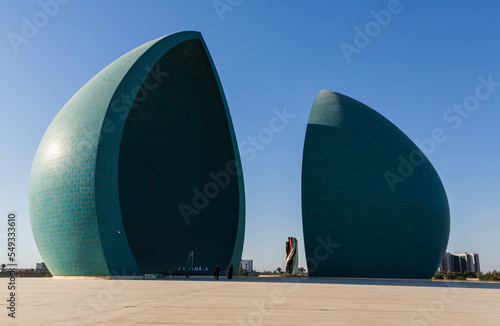 Baghdad, Iraq - November 2022: Split turquoise domes of Al Shaheed war memorial also called as Martyr's monument at the centre of the two half-domes is the Iraqi flag