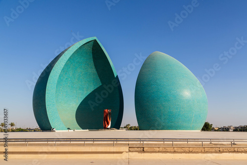 Baghdad, Iraq - November 2022: Split turquoise domes of Al Shaheed war memorial also called as Martyr's monument at the centre of the two half-domes is the Iraqi flag