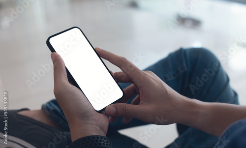 Mobile phone mockup for advetising. Mock up image of man hand holding and using smartphone with blank screen for mobile app design or text advertisement