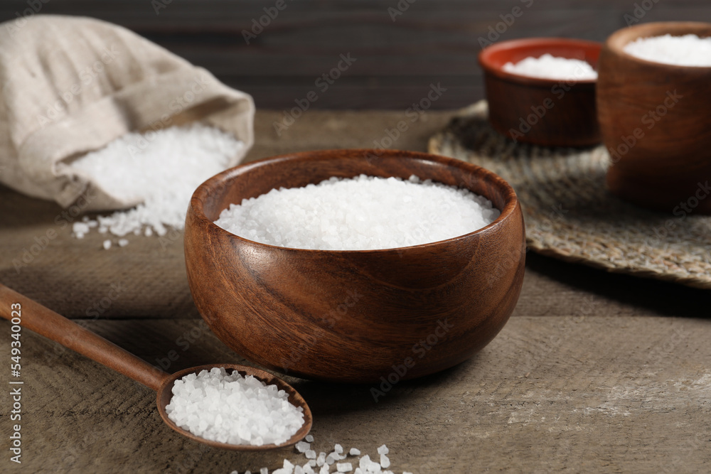 Bowl and spoon with natural sea salt on wooden table