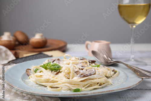 Delicious pasta with mushrooms and cheese on white wooden table, closeup
