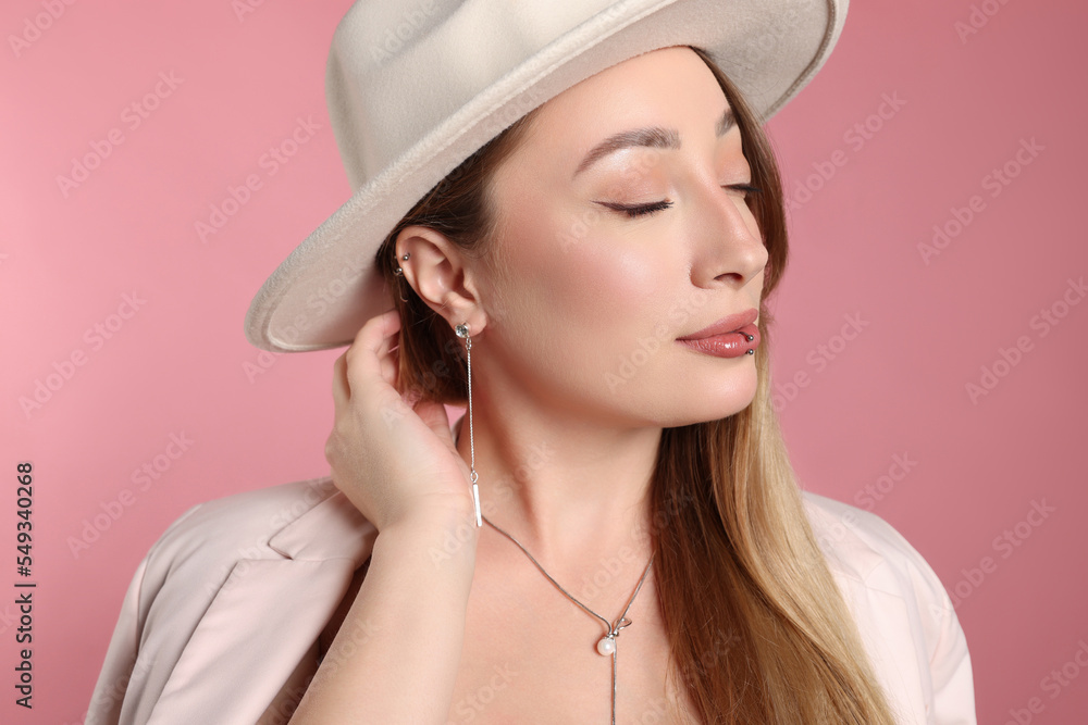 Young woman with lip and ear piercings on pink background Young woman with lip and ear piercings on pink background