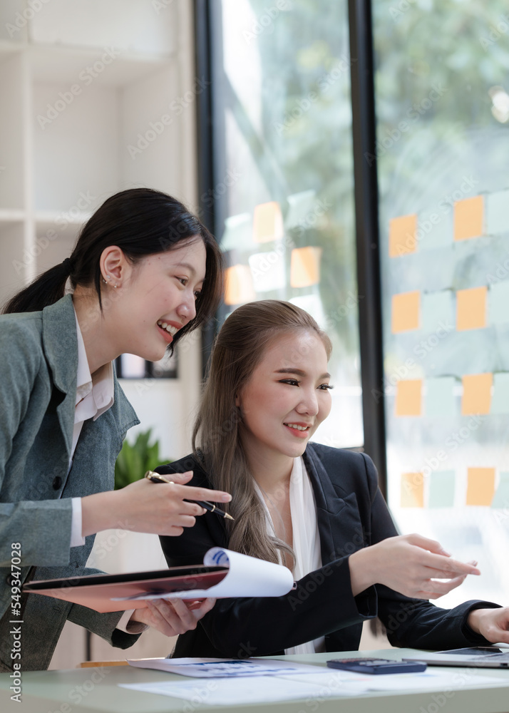 Female business worker with colleagues in Thailand working together at office desk, Female office worker business suit working with document file and paper work. Female business worker with colleagues in Thailand working together at office desk, Female office worker business suit working with document file and paper work.