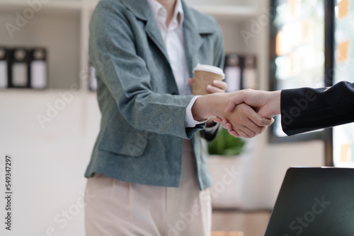 Female business worker with colleagues in Thailand working together at office desk  getting shaking hands  successful and agreement concept