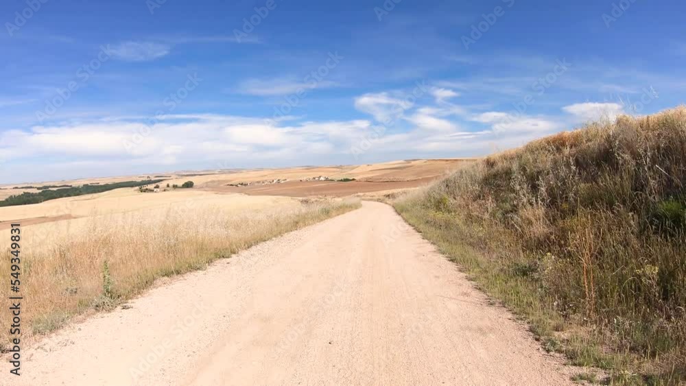 Camino de Madrid - a dirt road on a summer landscape next to Los Huertos, province of Segovia, Castile and León, Spain Camino de Madrid - a dirt road on a summer landscape next to Los Huertos, province of Segovia, Castile and León, Spain
