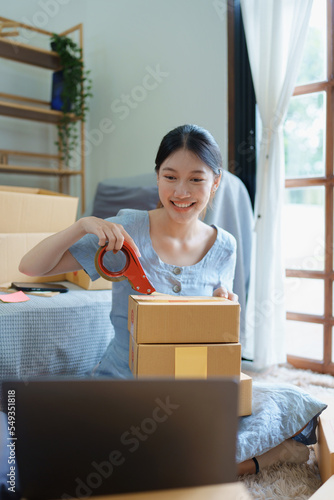 Starting small business entrepreneur of independent Asian female online seller packing products to send to customers and SME delivery concept