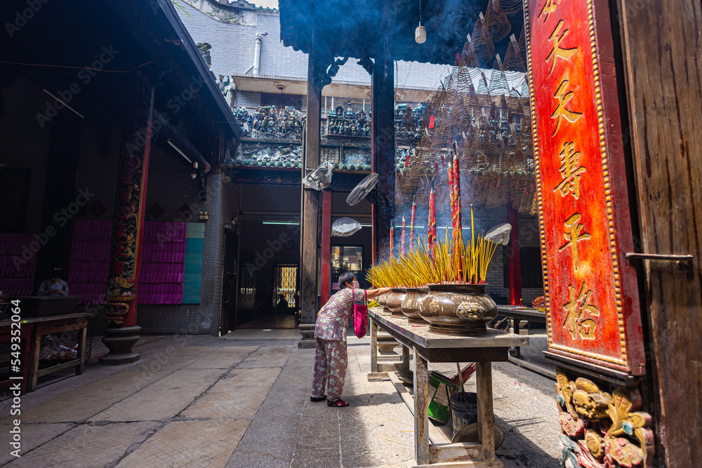 Naklejka premium HO CHI MINH CITY, Vietnam - November 08, 2022 - Chua Ba Thien Hau Pagoda in Saigon. Inside Thien Hau Temple, Chinese-style temple of the Chinese sea goddess Mazu. People with burning incense praying.