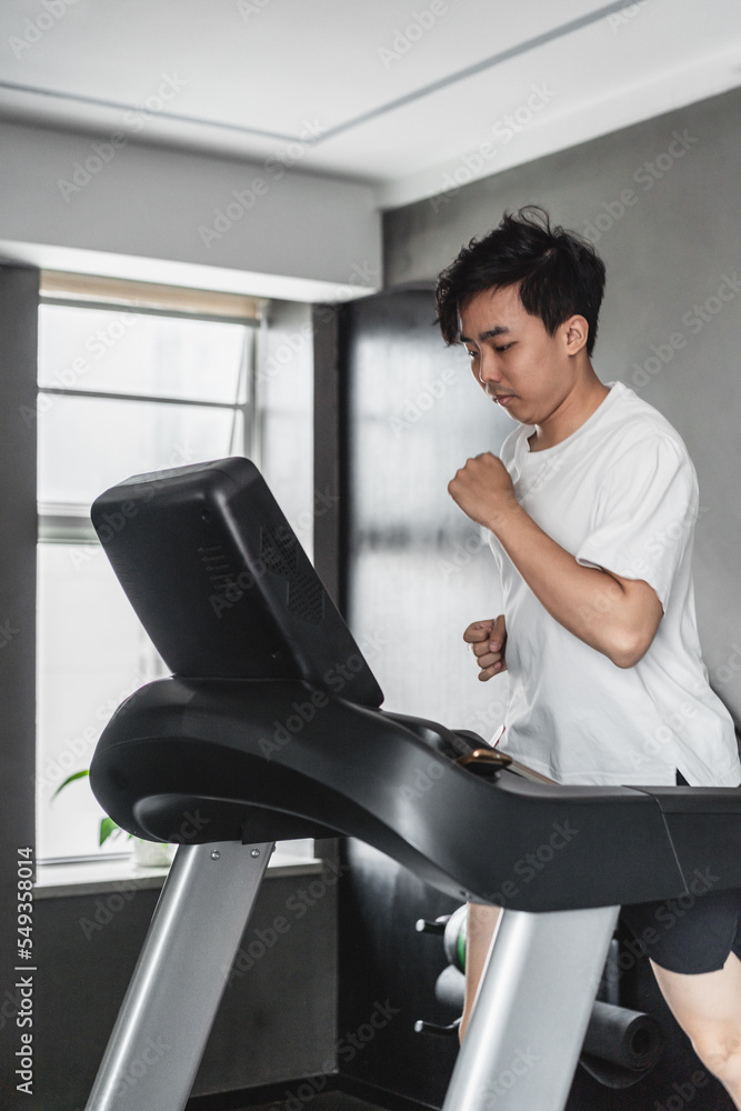 Asian man is running on the treadmill in the gym. Asian man is running on the treadmill in the gym.