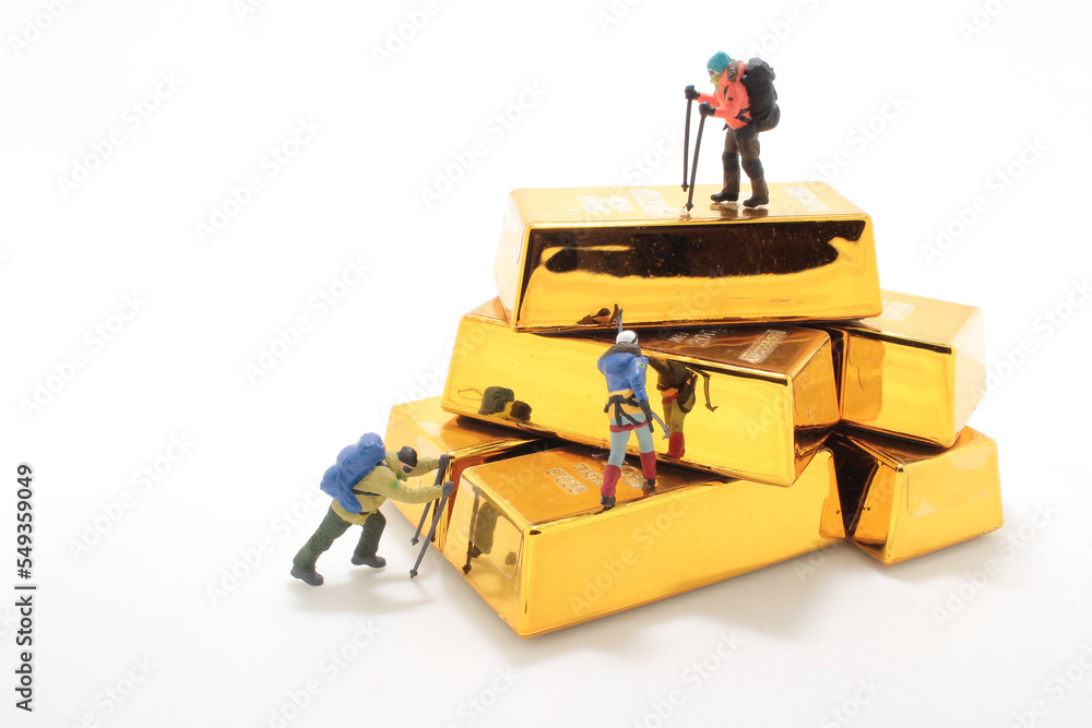 Obraz premium the mini figure climbs a ladder of bars of gold.