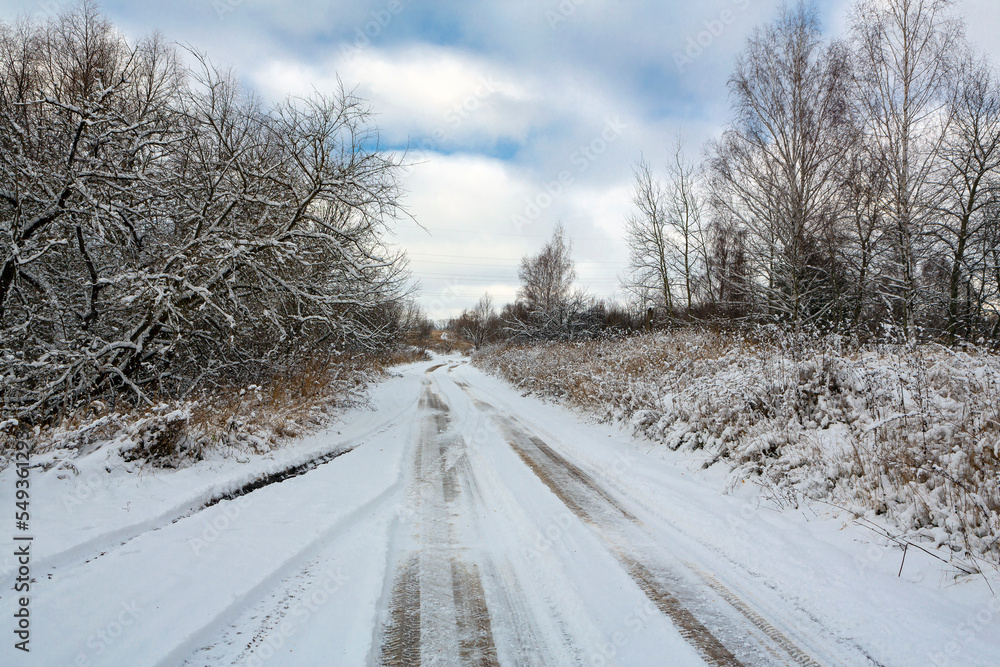 A snow-covered winter country road stretching into the distance. A snow-covered winter country road stretching into the distance.