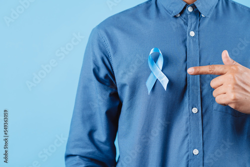 men hands showing Blue ribbon for supporting people living and illness, Colon cancer, Colorectal cancer, Child Abuse awareness, world diabetes day, International Men's Day