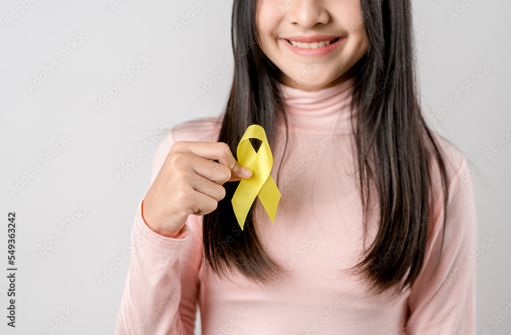 happy woman holding yellow ribbon, september, suicide prevention day, childhood, sarcoma, bone and bladder cancer Awareness month, health care support people and world cancer day concept. happy woman holding yellow ribbon, september, suicide prevention day, childhood, sarcoma, bone and bladder cancer Awareness month, health care support people and world cancer day concept.