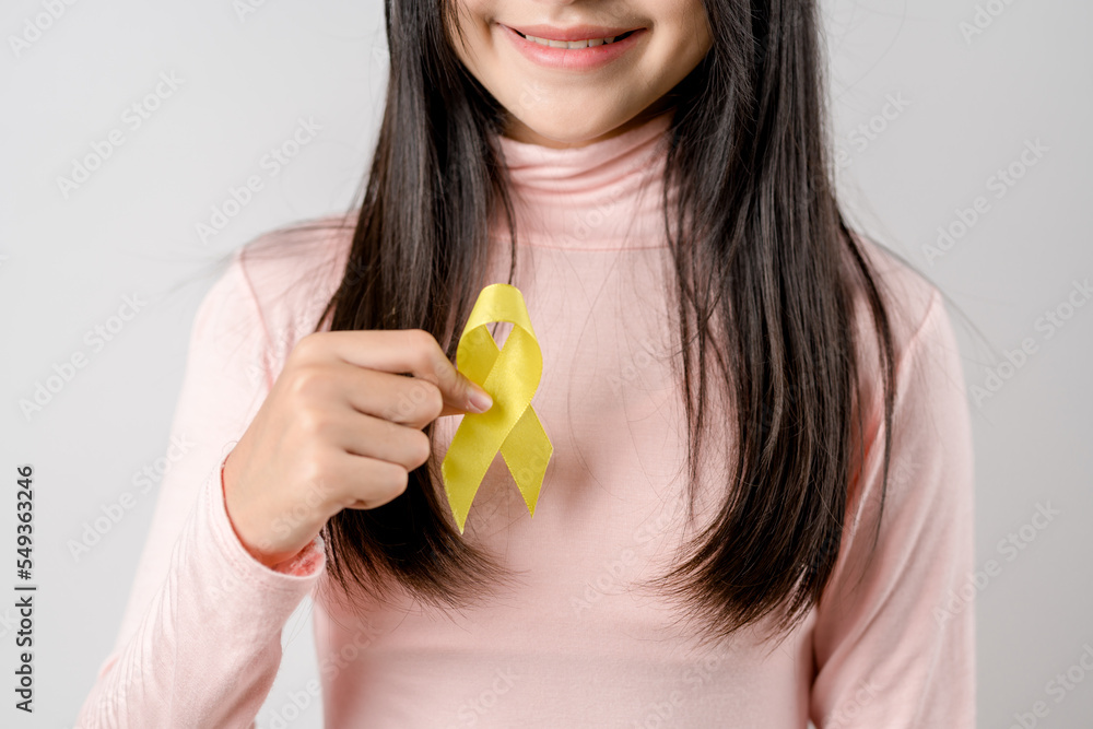 happy woman holding yellow ribbon, september, suicide prevention day, childhood, sarcoma, bone and bladder cancer Awareness month, health care support people and world cancer day concept.