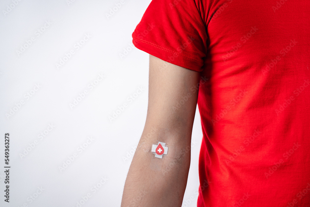 man showing plaster after donation blood, blood transfusion, world blood donor day, world hemophilia day concept. фотография Stock