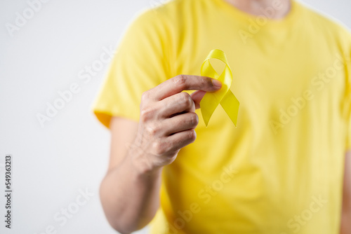 man showing yellow ribbon, september, suicide prevention day, childhood, sarcoma, bone and bladder cancer Awareness month, health care support people and world cancer day concept.