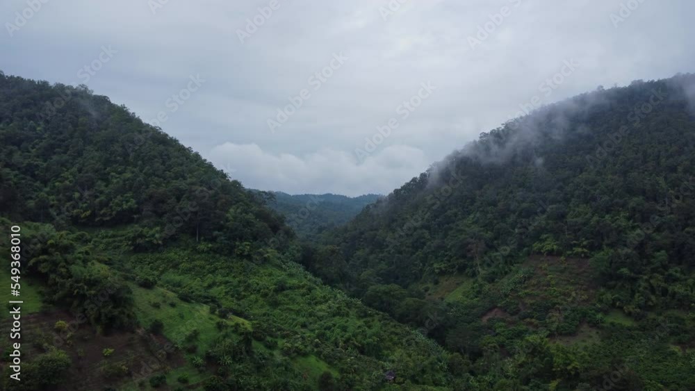 Aerial view of a village on a plateau with fog in the morning. Top view from a drone of a village against a mountainous background during winter in Thailand. Natural landscape background.