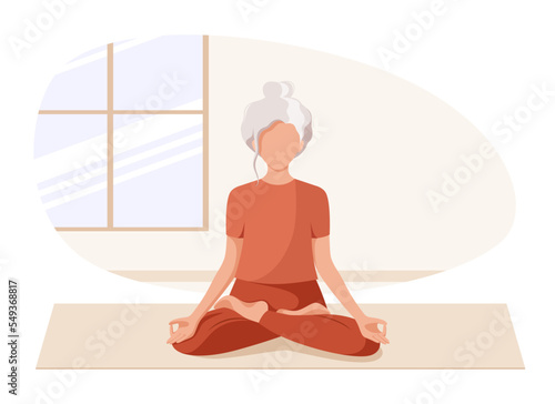 An elderly woman in the lotus position. Yoga classes. Active old age.