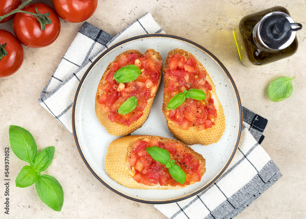 Crispy bruschetta with tomatoes, herbs and olive oil on a white plate, top view. Italian appetizers. Crispy bruschetta with tomatoes, herbs and olive oil on a white plate, top view. Italian appetizers.