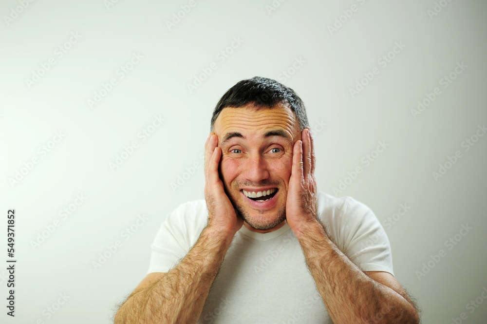 wrinkle forehead stick out tongue Different cheerful positive emotions of adult man black hair Open funny cheerful blue eyes White t-shirt gray background Hairy male hands Win Win fun vacation travel wrinkle forehead stick out tongue Different cheerful positive emotions of adult man black hair Open funny cheerful blue eyes White t-shirt gray background Hairy male hands Win Win fun vacation travel
