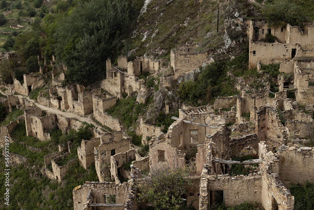 Ruin of medieval stone fort in highlands of Dagestan in summer, detail of abandoned and destruction stone buildings and street in old city. Wonder trip in traditional caucasian nations, mode of life.