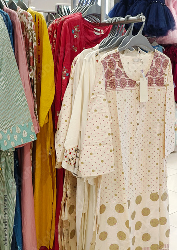 Female casual clothes in boutique, clothes with a selection of ladies fashion, Colorful women's dresses on hangers in a retail shop in India. © Vinayak Jagtap