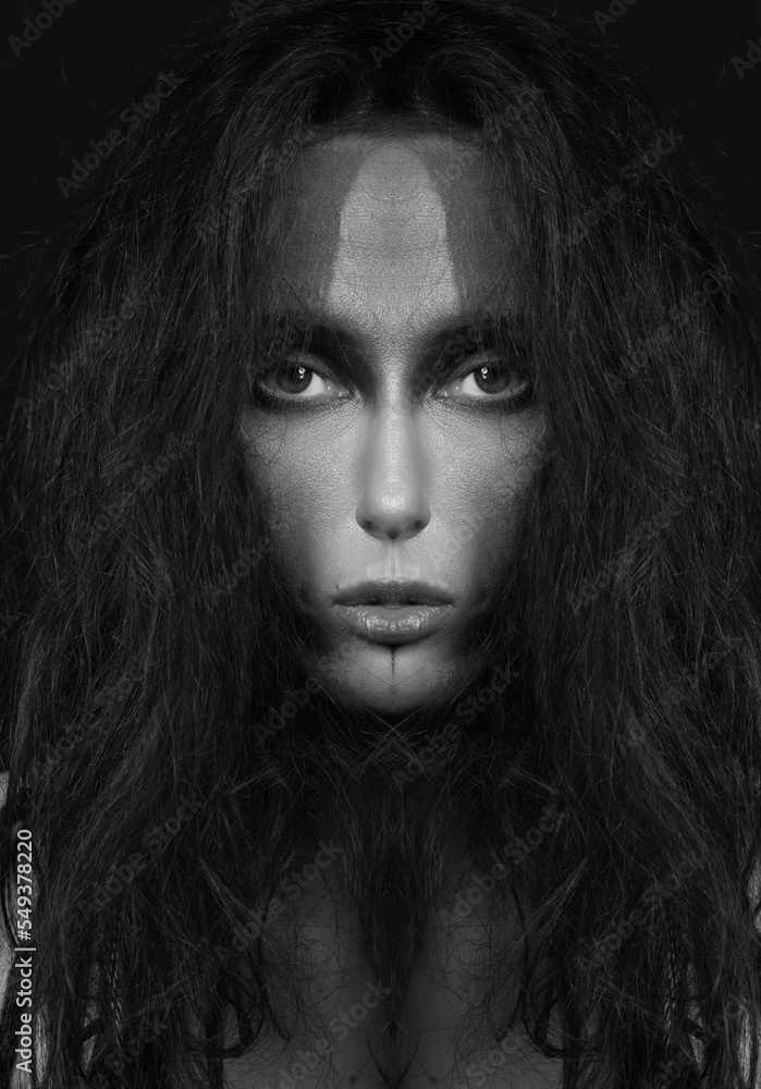 Fine art and sci-fi concept. Abstract and futuristic looking alien or extraterrestrial looking being close-up portrait. Strange looking model with messy hair portrait. Black and white image