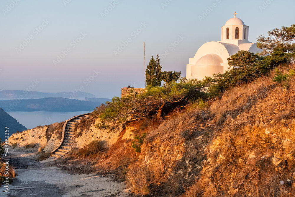 White church on a hill at sunrise at Santorini island, Greece