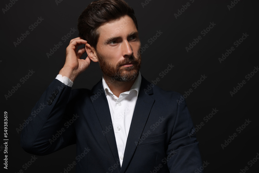 Portrait of handsome bearded man looking away on black background. Space for text Portrait of handsome bearded man looking away on black background. Space for text