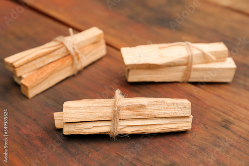 Bunches of tied Palo Santo sticks on wooden table, closeup