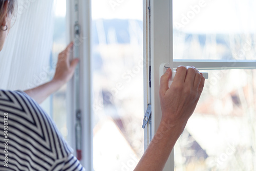 Frauenhände beim Öffnen eines Fenster zum Lüften der Wohnung - Konzept zum richtigen Heizen und Lüften