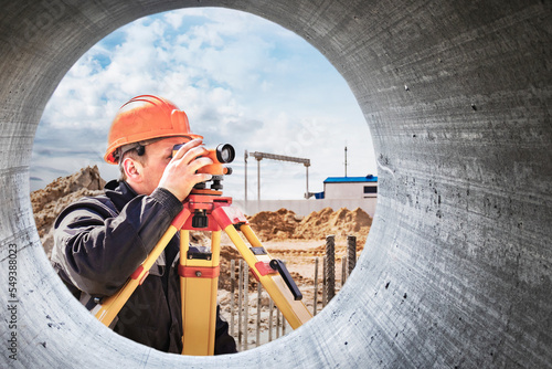 Surveyor engineer is measuring level on construction site. Surveyors ensure precise measurements before undertaking large construction projects. Design work in construction. Close-up.