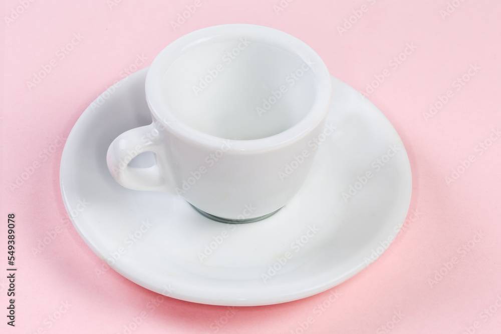 Small empty white coffee cup with handle on the saucer Small empty white coffee cup with handle on the saucer
