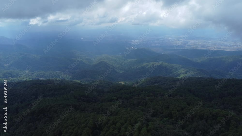 Aerial view of tropical forest with mist in the morning. Top view from drone of beautiful mountain tropical forest during winter in Thailand. Natural landscape background. Aerial view of tropical forest with mist in the morning. Top view from drone of beautiful mountain tropical forest during winter in Thailand. Natural landscape background.