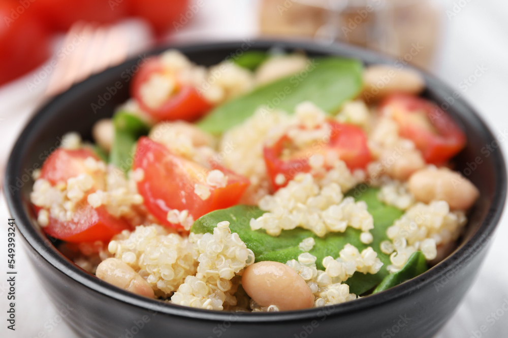 Delicious quinoa salad with tomatoes, beans and spinach leaves, closeup Delicious quinoa salad with tomatoes, beans and spinach leaves, closeup