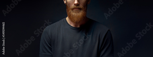 Young caucasian male beard closeup. Young bearded hipster in black blank t-shirt. Handsome confident perfect hairstyle man.