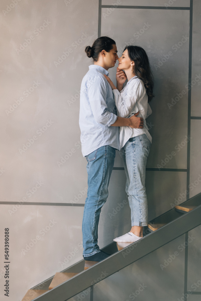 Full length of young couple sitting on stairs in house