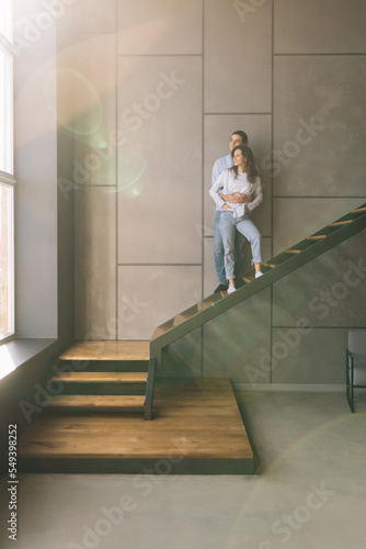 Handsome guy and his pretty lady sitting on stairs in interior room indoors moving to new flat together © F8  \ Suport Ukraine