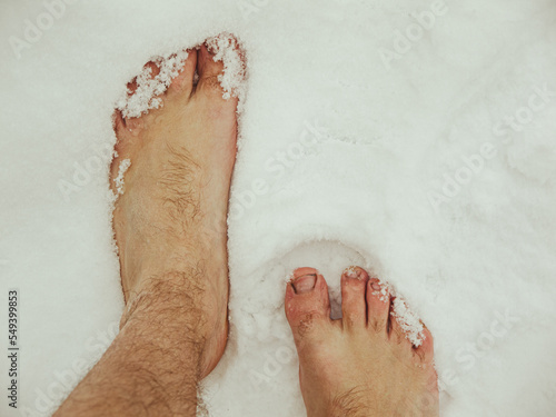 Canvas-taulu a man walks barefoot in the snow, hardening and a healthy lifestyle