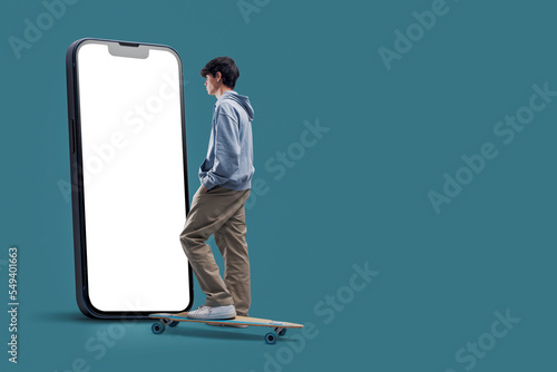 Teenage skater and big smartphone