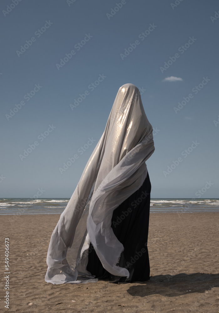 abstract portrait of woman in black dress on the beach hiding under ...