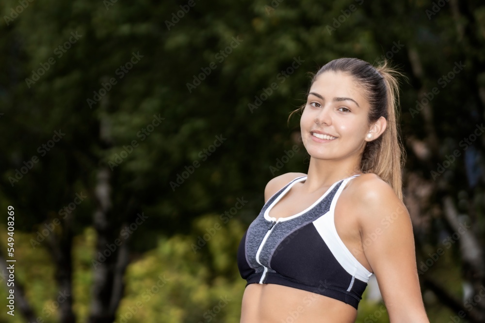 Portrait of a smiling woman sitting on the ground in the city street after running. A healthy runner resting after exercise. Active sporty woman Portrait of a smiling woman sitting on the ground in the city street after running. A healthy runner resting after exercise. Active sporty woman