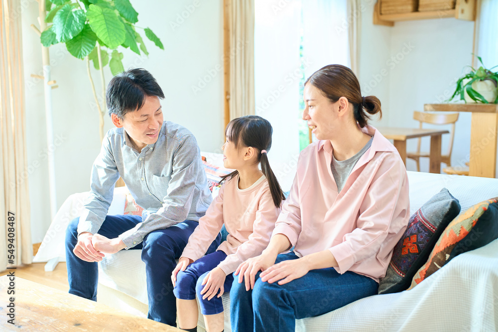 Obraz premium リビングルームで楽しそうに話す親子3人