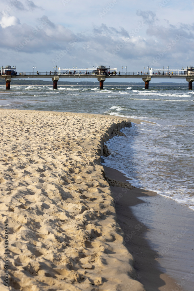 Fototapeta premium Miedzyzdroje, Poland - September 15, 2022: Miedzyzdroje pier, long wooden jetty entering the Baltic Sea from the beach, beautiful seaside landscape