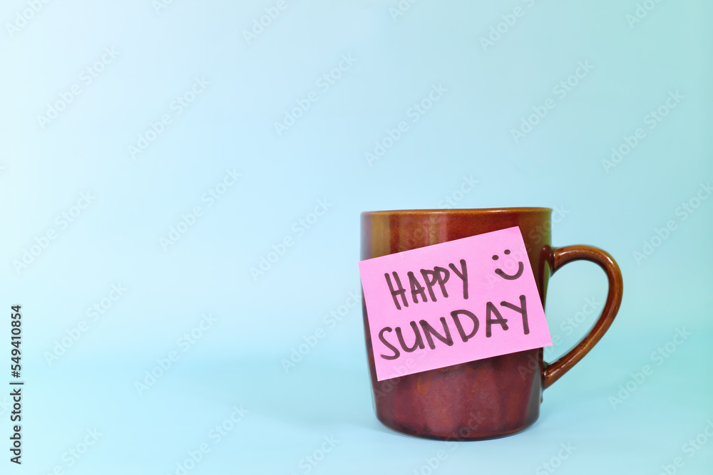 Welcome, hello and happy Sunday concept. Selective focus of coffee cup with pink paper note and written message. Welcome, hello and happy Sunday concept. Selective focus of coffee cup with pink paper note and written message.