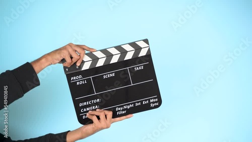 Hand is holding clapper board or clapperboard or movie slate, used in film production and cinema ,movies industry isolated over color background. photo