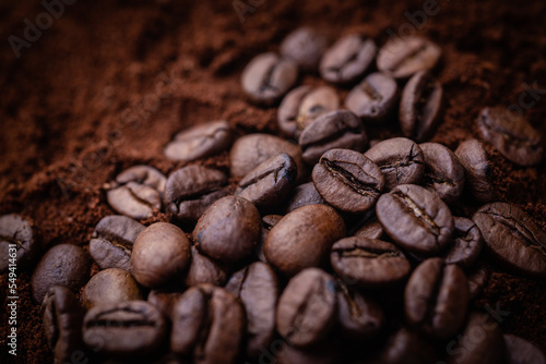 Roasted coffee .Close up. Lying on a bed of ground coffee. Studio macro photography.