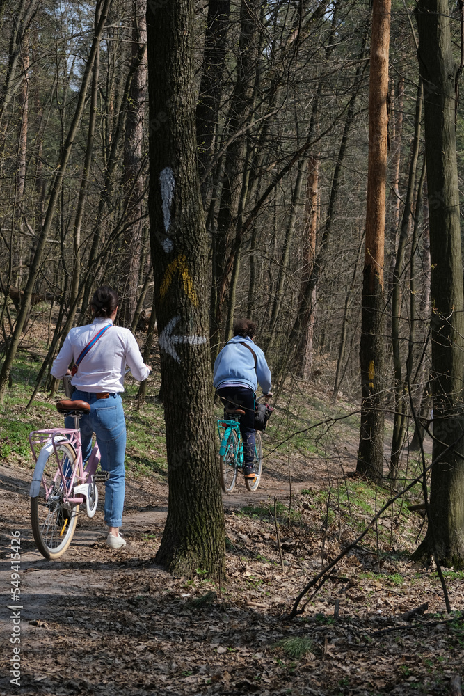 Obraz premium A portrait shot of cyclists riding in a Spring forest at Holosiivskyi National Nature Park, Kyiv, Ukraine