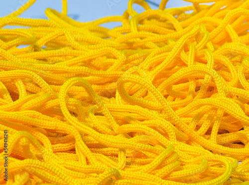 yellow rope mound. Coarse textured yarn strands stacked irregularly